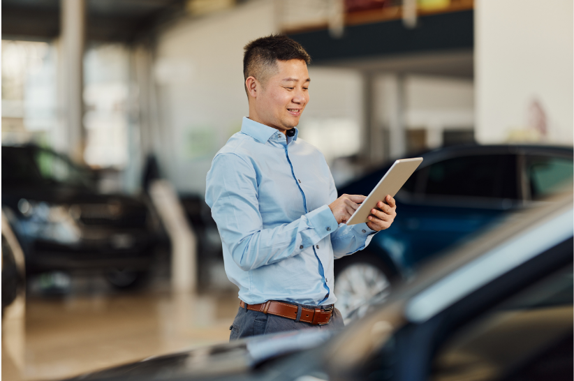 Man looking on his device in a dealership